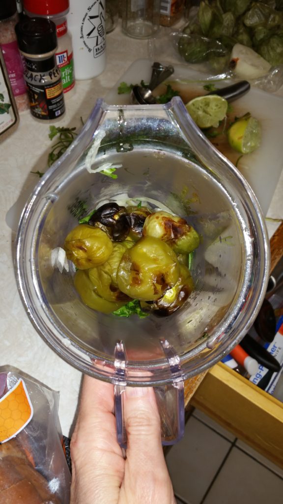 Broiled tomatillos have been added to the onion, cilantro, lime juice, and salt.