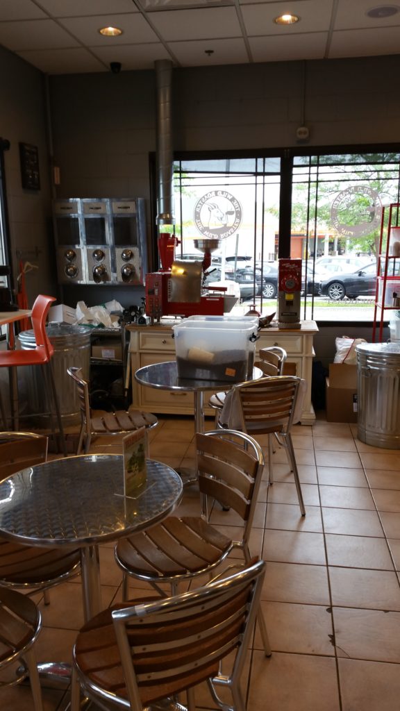 An inside view of the shop. (It was closed during this part of the day.) The cans in the background and plastic bin on the table are filled with coffee beans!