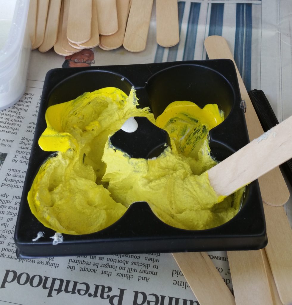 The grout was transferred into this container, and yellow paint was added and mixed in.