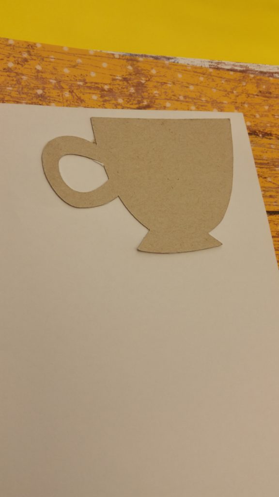 Simply gluing the cup cut-out onto the scrapbook paper.