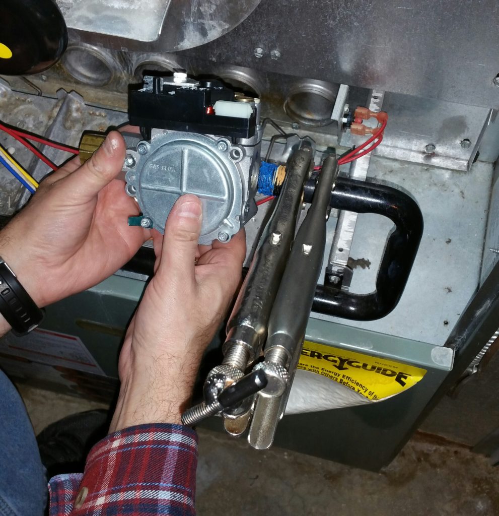 The new gas valve is carefully aligned so that it is level and doesn't contact other parts of the furnace.